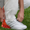 silver and orange adidas shoe with white sole and tongue zipper