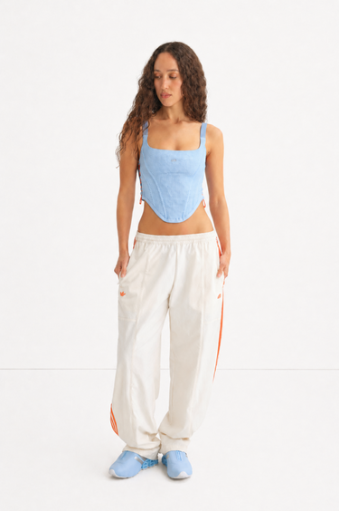 blue adidas corset and white adidas trackpant with orange stripes